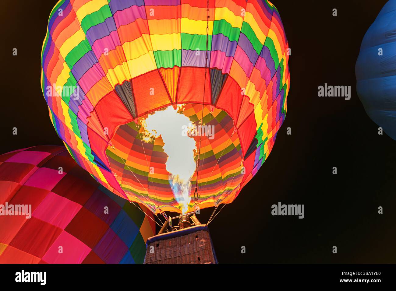 Pallone colorato ad aria calda con fiamme in fiamme durante la serata del festival Foto Stock