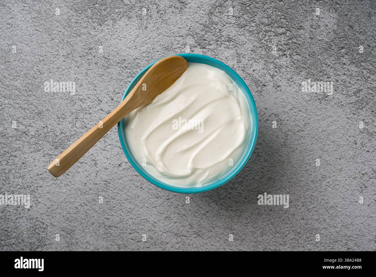 Vista dall'alto dello yogurt nel recipiente su un tavolo in pietra grigia. Concetto di alimentazione sana Foto Stock