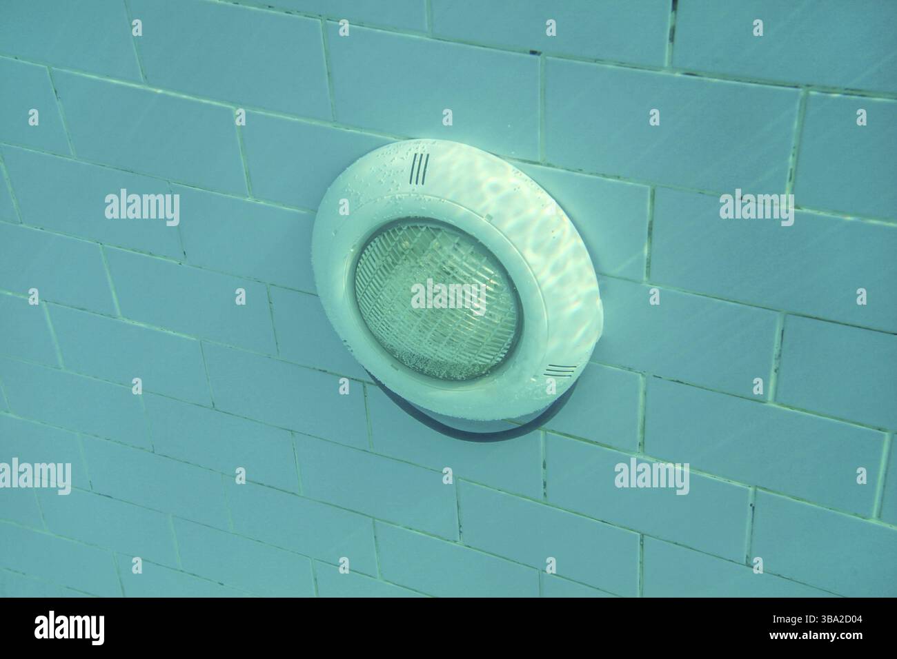 Luce elettrica in piscina su pareti in piastrelle blu, sole che splende dall'alto. Foto subacquea, Lapta, Cipro, Europa Foto Stock