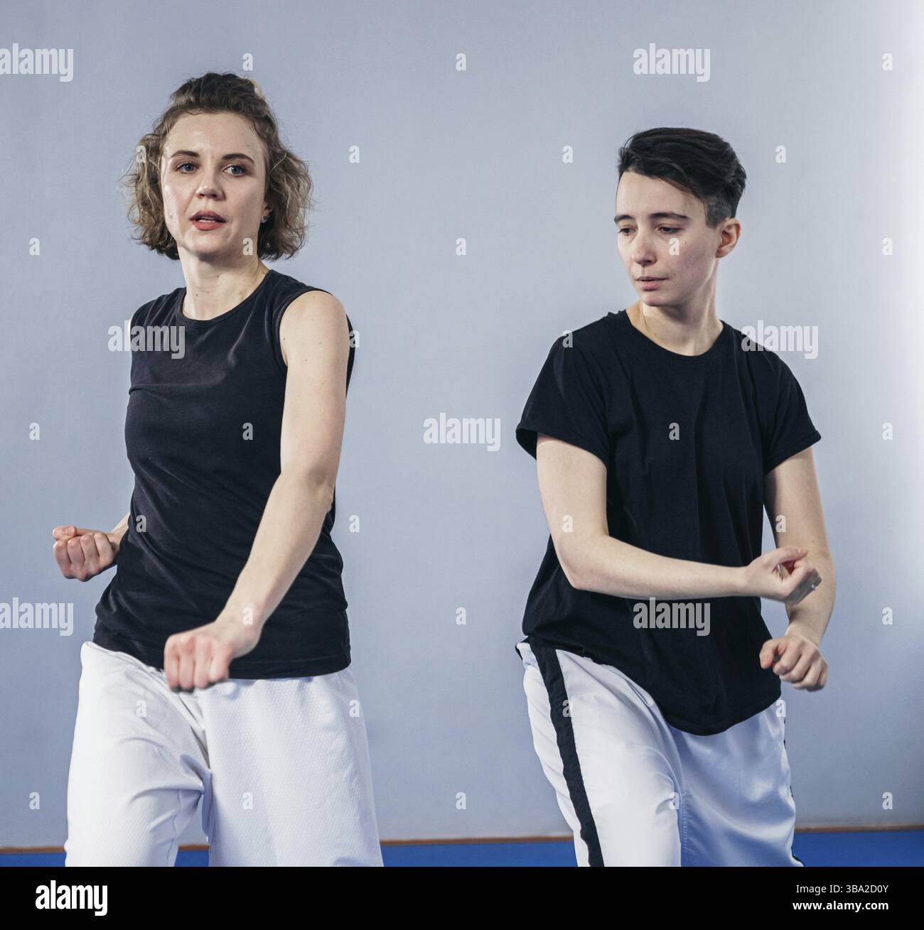 Due combattenti femminili di arti marziali praticano in palestra. Taekwondo allenatore e studente in formazione personale. Classe di autodifesa per le donne. Addestramento dei combattenti Foto Stock