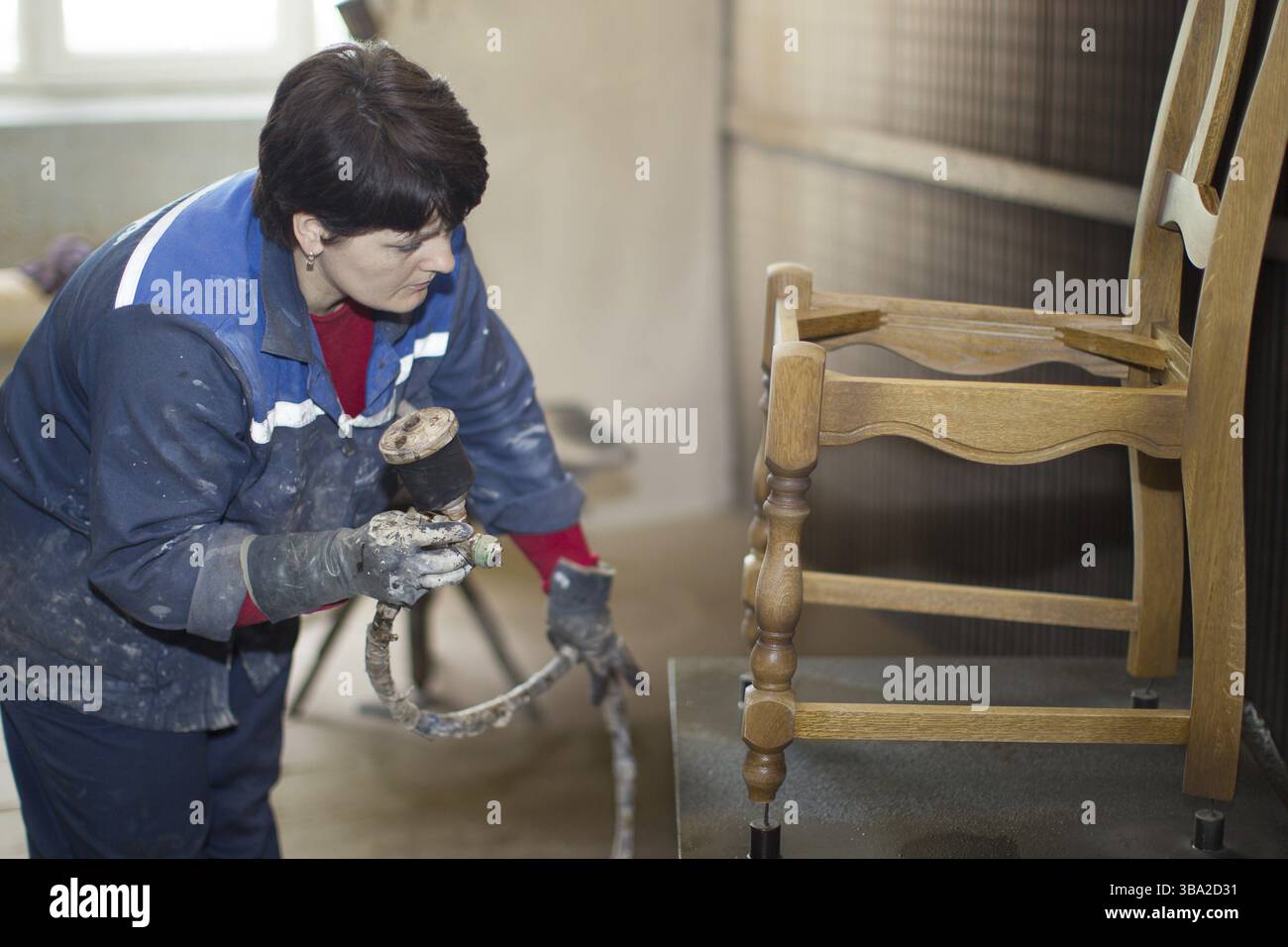 La Bielorussia, la città di Gomel, il 26 aprile 2018. Fabbrica di mobili. Un lavoro bullet-maker dipinge una sedia con una vernice. Fabbricazione di Mobili.Facendo chai Foto Stock