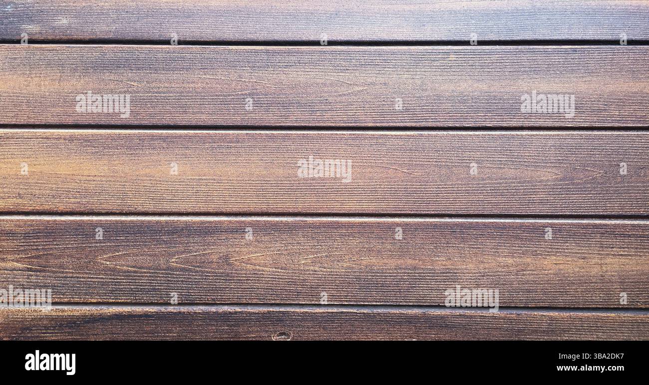 Fondo in legno marrone, quercia scura di legno satinato invecchiato con vernice sbiadita che mostra la consistenza della venatura del legno. lavare le tavole di legno duro Foto Stock