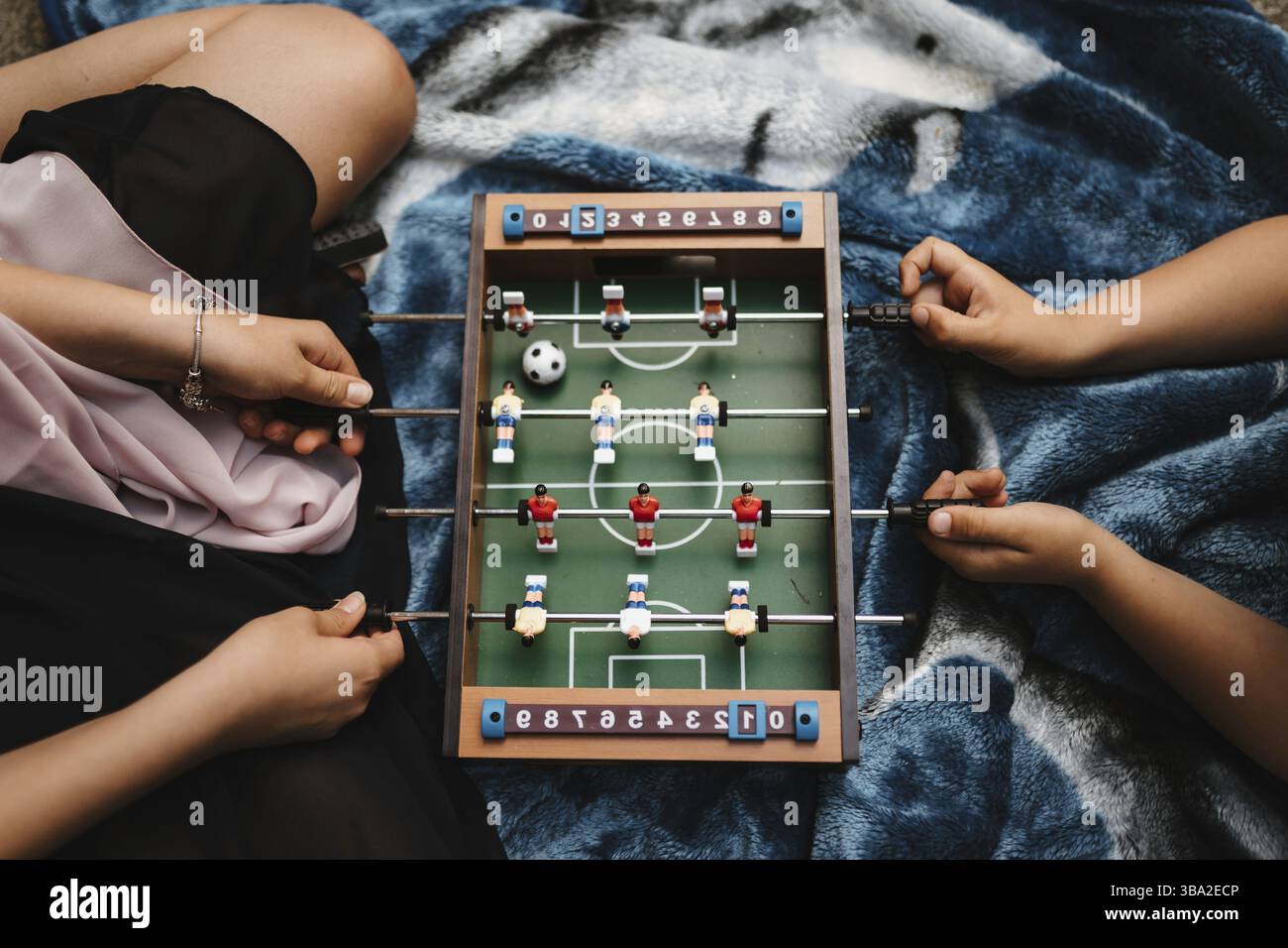 Foto di una madre che gioca con suo figlio con un tavolo da calcio Foto Stock