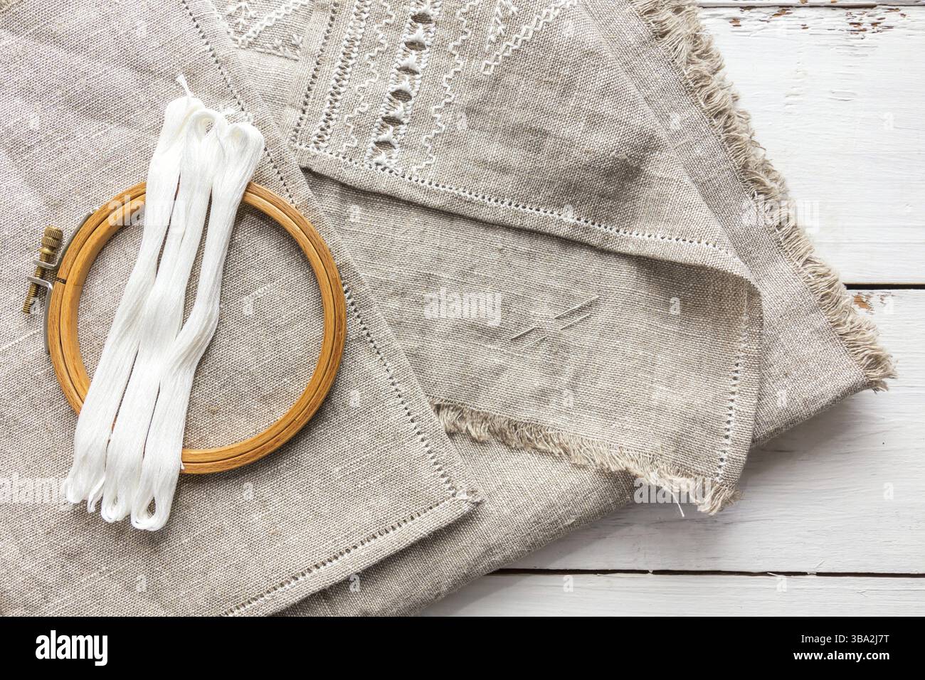Impostare per il ricamo. Filo da ricamo di colore bianco, ricami hoop e ago su lino con ricamo in corso. La colorazione e l'elaborazione di foto. Sh Foto Stock