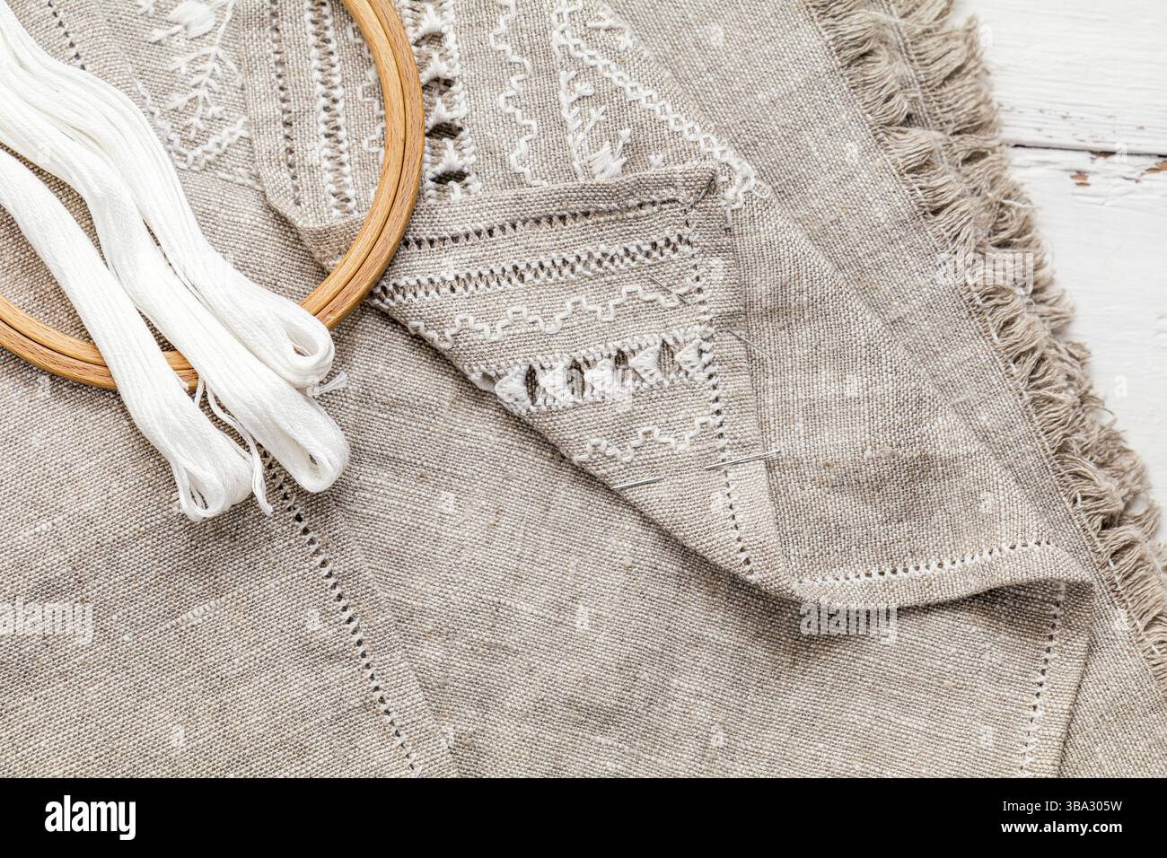 Impostare per il ricamo. Filo da ricamo di colore bianco, ricami hoop e ago su lino con ricamo in corso. La colorazione e l'elaborazione di foto. Sh Foto Stock