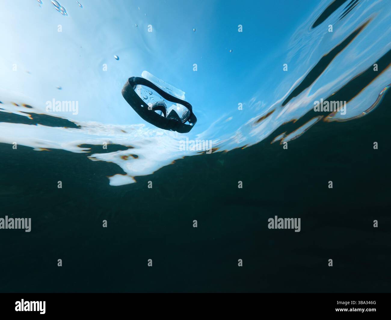 Maschera subacquea che galleggia nell'acqua dell'oceano, ripresa subacquea con vista ad angolo basso, messa a fuoco selettiva Foto Stock