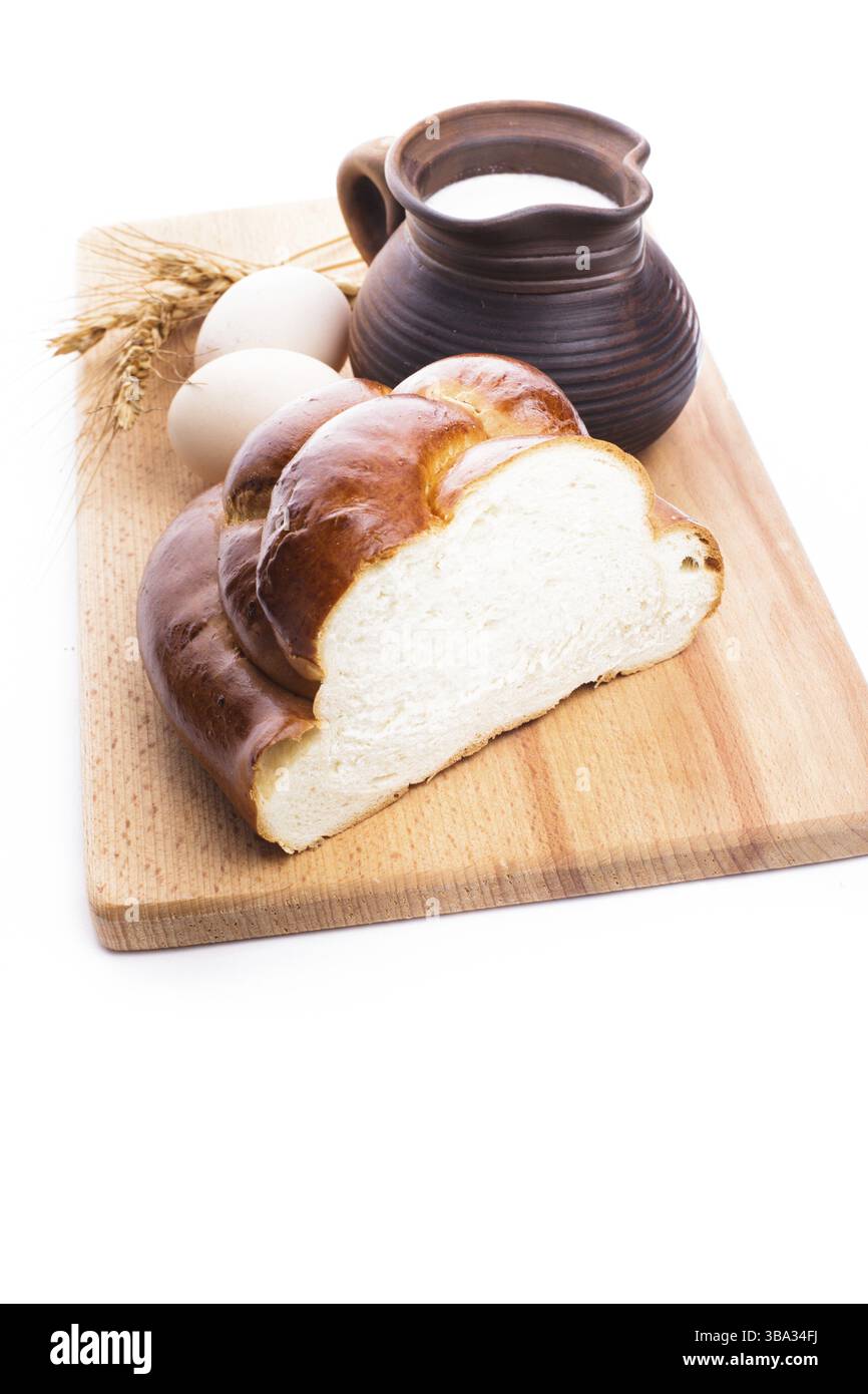 Pane fresco di challah con latte e uova sul pannello di legno Foto Stock