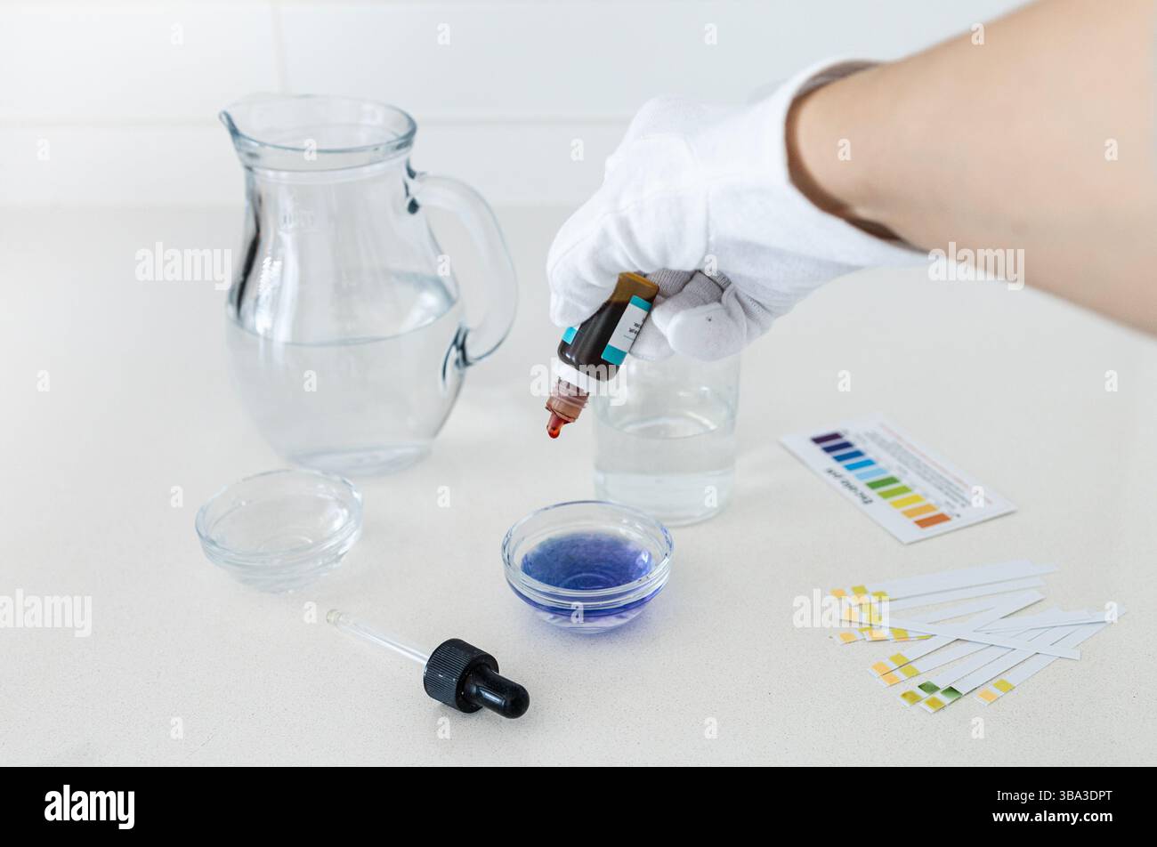 Fotografie di un kit per l'analisi del pH dell'acqua con gocce di indicatore colore e una tabella di confronto, utilizzate per analizzare l'acidità o l'alcalinità del consumo di wa Foto Stock