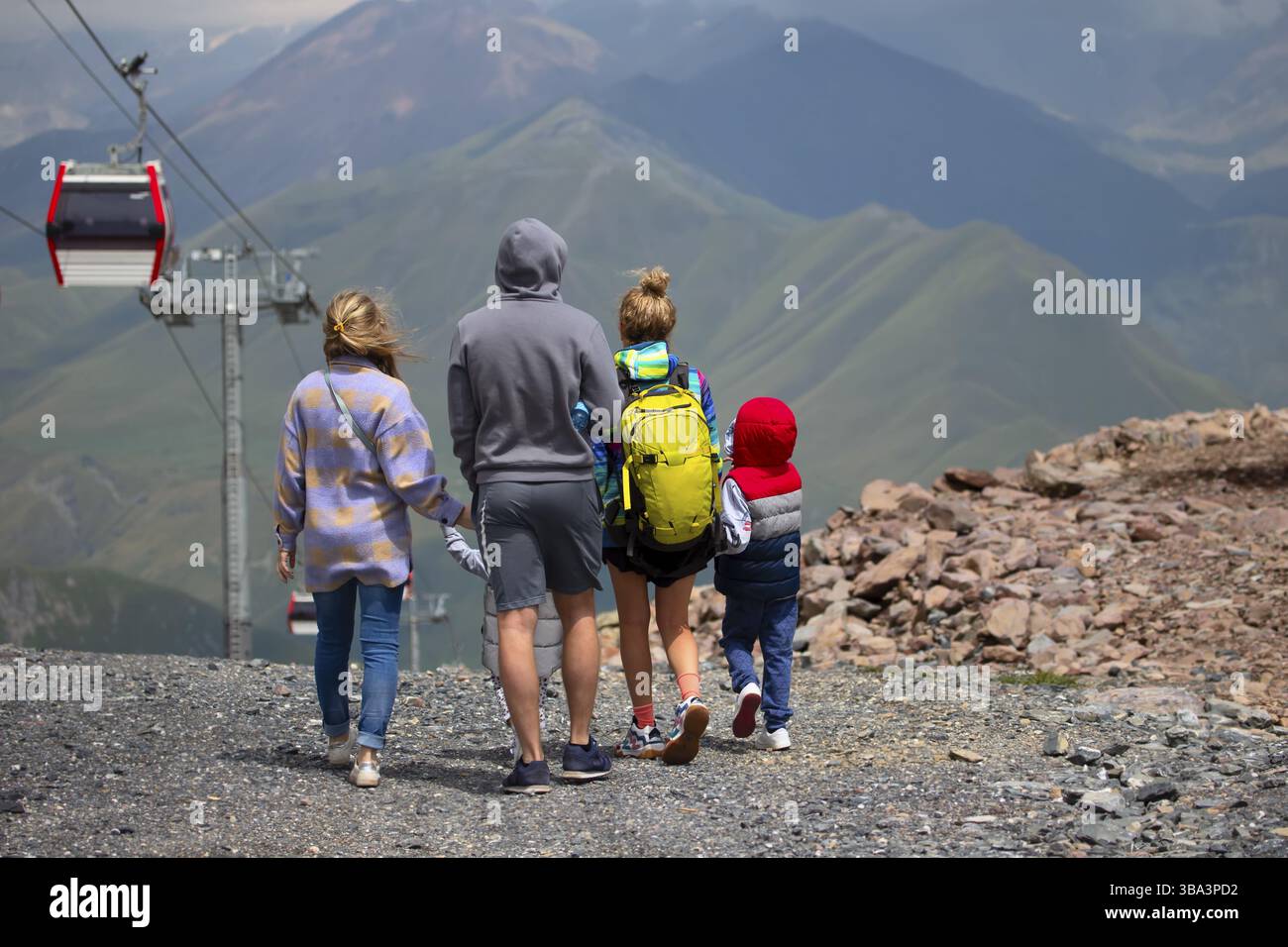 Un gruppo di persone, una famiglia viaggia in una zona montuosa, fa un giro in funivia Foto Stock