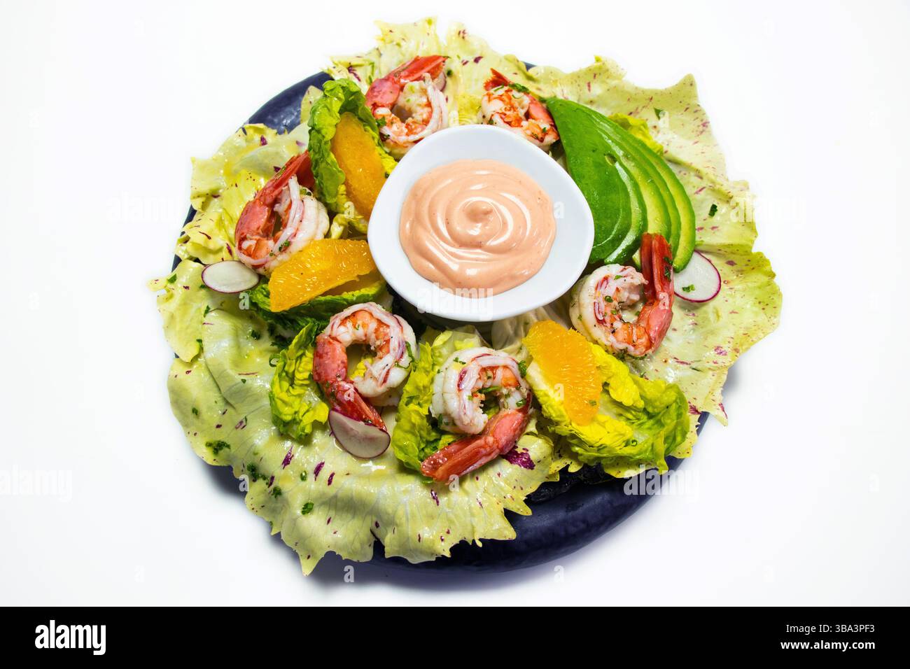 gamberi in camicia, avocado, lattuga, arancia e salsa cocktail con sfondo bianco Foto Stock