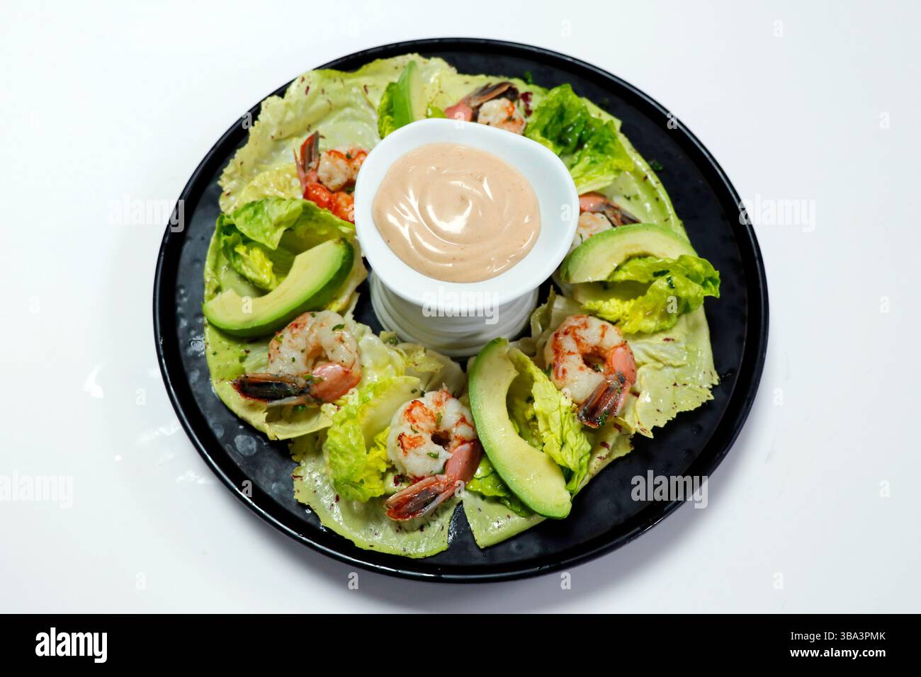 gamberi in camicia, avocado, lattuga, arancia e salsa cocktail con sfondo bianco Foto Stock