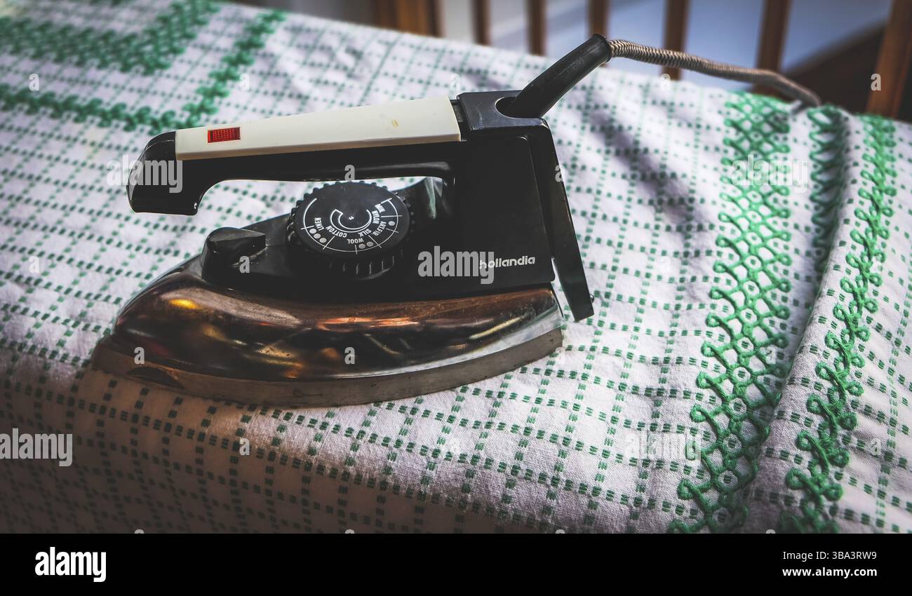 Antico strumento di stiratura su un bianco panno verde Foto Stock