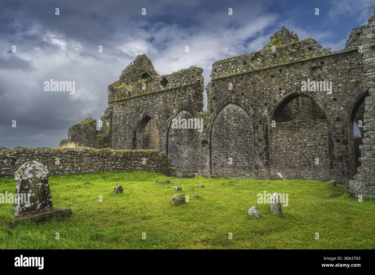 Pietre tombali e rovine della vecchia Abbazia di Hore abbandonata con un suggestivo cielo di tempesta. Situato vicino al castello Rock of Cashel, alla contea di Tipperary, Irlanda, Europa Foto Stock