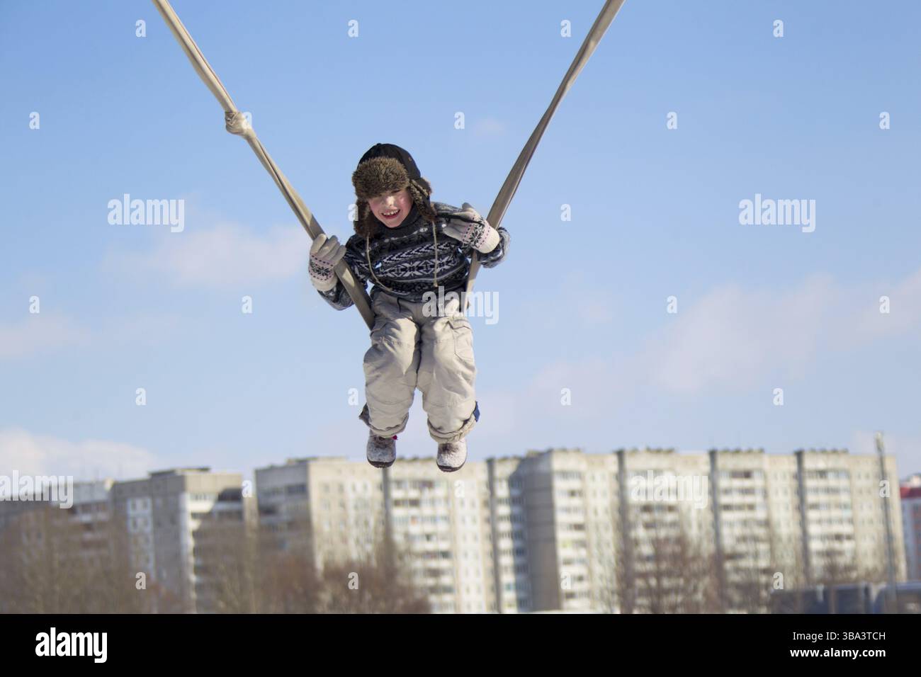 Il bambino è in sella ad alta su un altalena dalla fune Foto Stock