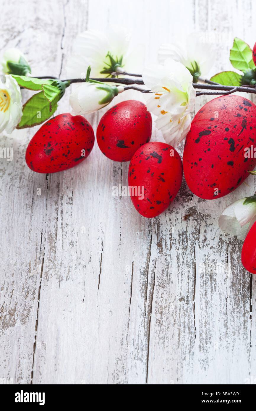 Red spotted uova con fiori di Apple sul malandato tavolo in legno Foto Stock