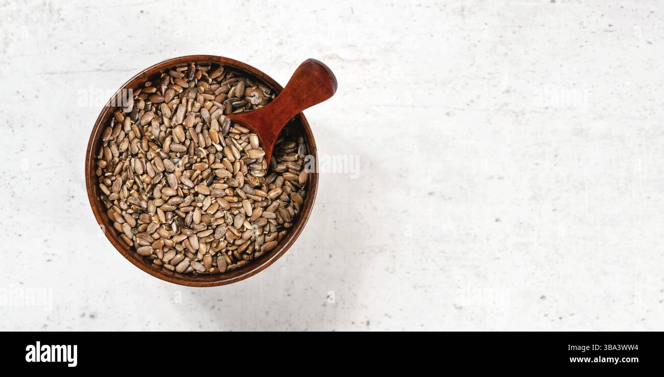 Semi di cardo mariano beato - Silybum marianum - in una piccola ciotola di legno in pietra bianca, vista dall'alto, spazio per testo lato destro, Liptovsky HRA Foto Stock
