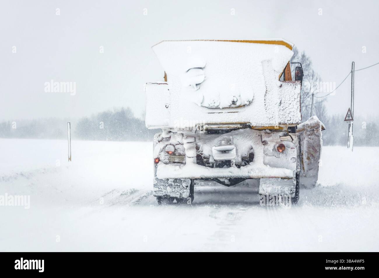 Arare il camion taglierina su una strada coperta di neve durante la tempesta di neve, vista dall'auto dietro, Podbanske, Slovacchia, Europa Foto Stock