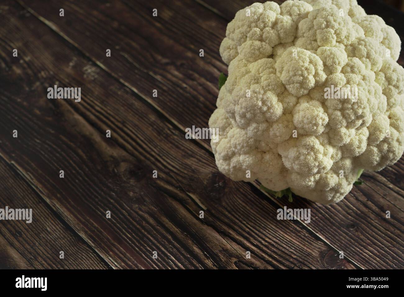 Testa di cavolfiore bianca senza foglie su tavola di legno scuro, spazio per testo a sinistra, Liptovsky Hradok, Slovacchia, Europa Foto Stock