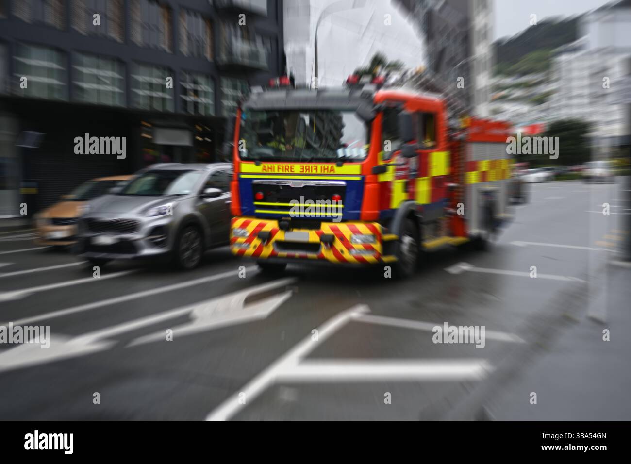 Il movimento radiale si sfoca su un camion dei pompieri che corre lungo una strada cittadina Foto Stock