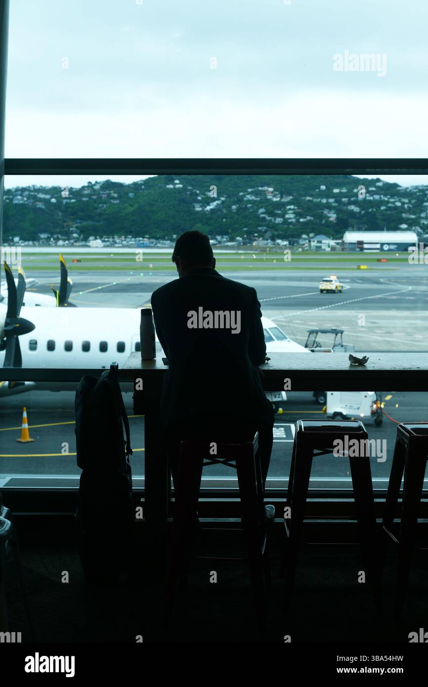 Un passeggero preferisce il suo tempo in una sala d'attesa dell'aeroporto Foto Stock