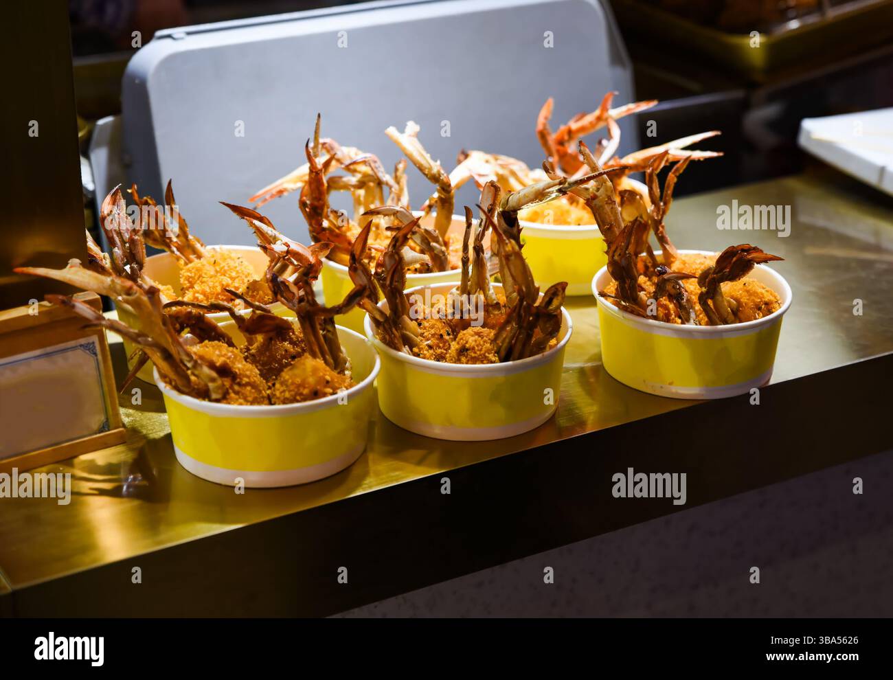 Ciotole di cibo di strada piene di artigli di granchio in pastella a Shanghai, Cina. Fritto alla perfezione con un rivestimento saporito, servito caldo e pronto Foto Stock