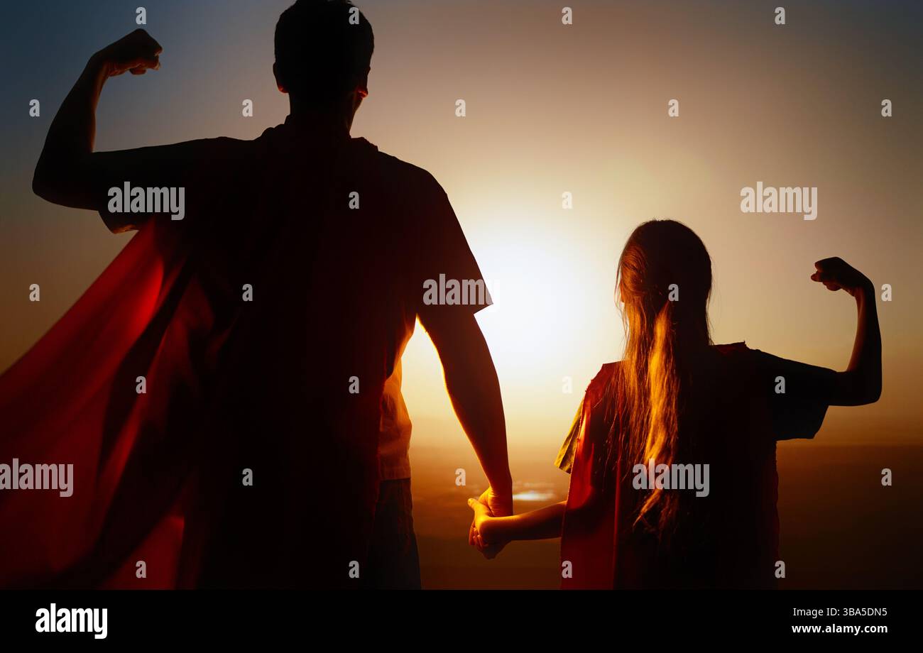 Famiglia felice amorevole. Padre e sua figlia giocano all'aperto. Daddy e la sua bambina in costumi di un Supereroe. Foto Stock