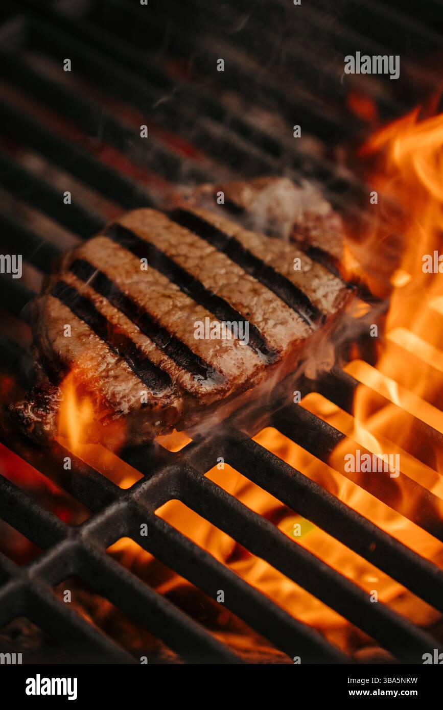 Grigliatura della New York Strip sulla fiamma libera sul barbecue. Foto Stock