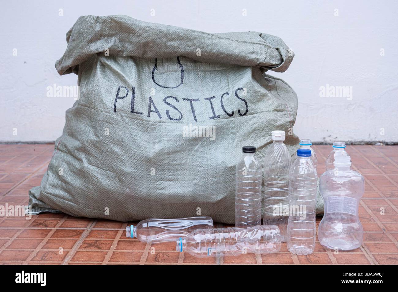 grande sacchetto per rifiuti con testo in plastica etichettato per la separazione di bottiglie in plastica per il riciclaggio, un concetto di responsabilità ambientale sostenibile. Foto Stock