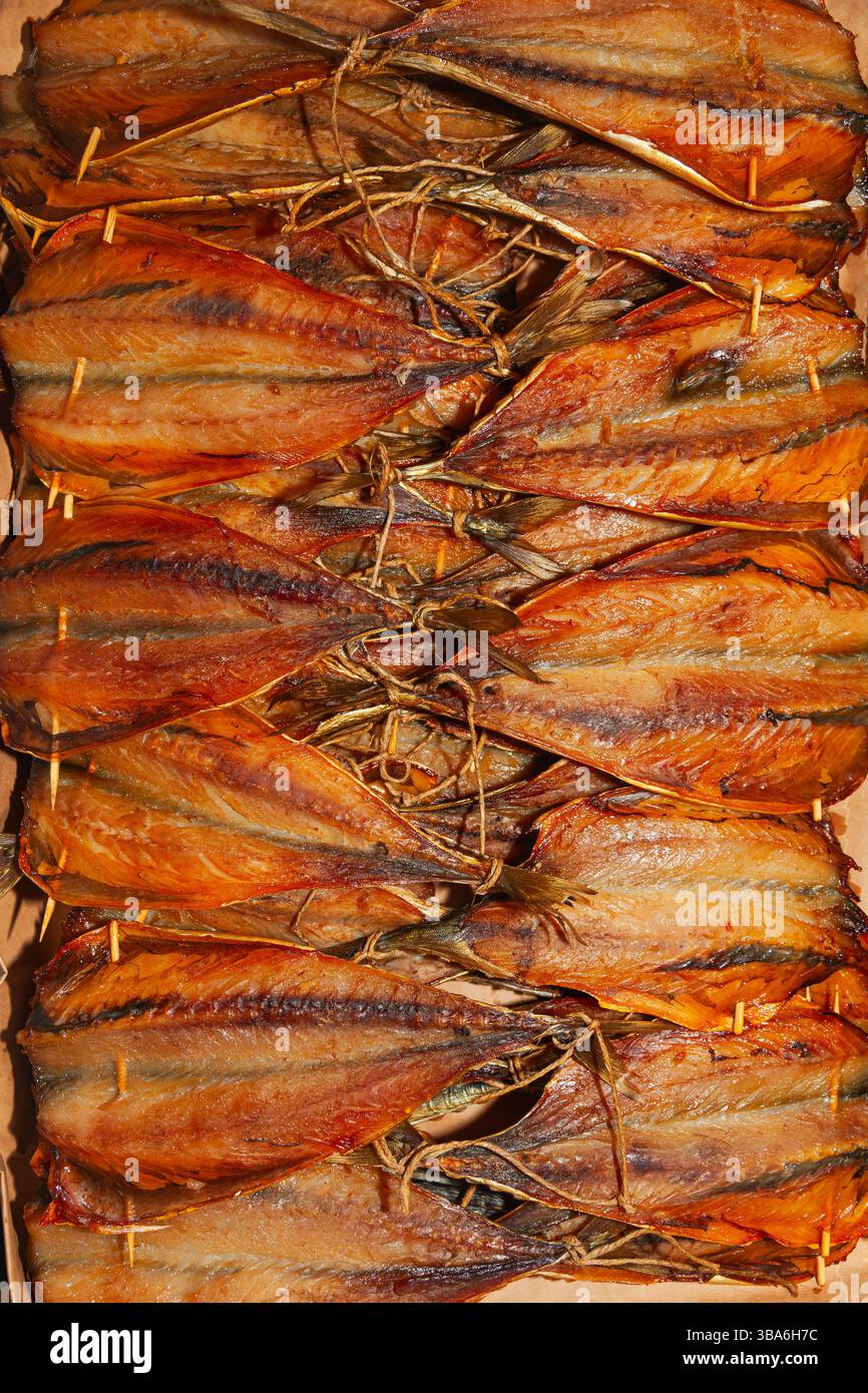 Primo piano di un lotto di pesce affumicato tagliato e finito. Foto Stock