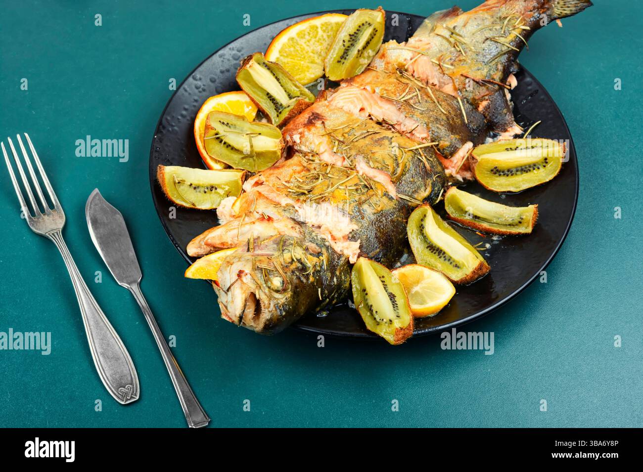 Trota tostata su un piatto, trota al forno con frutta. Foto Stock