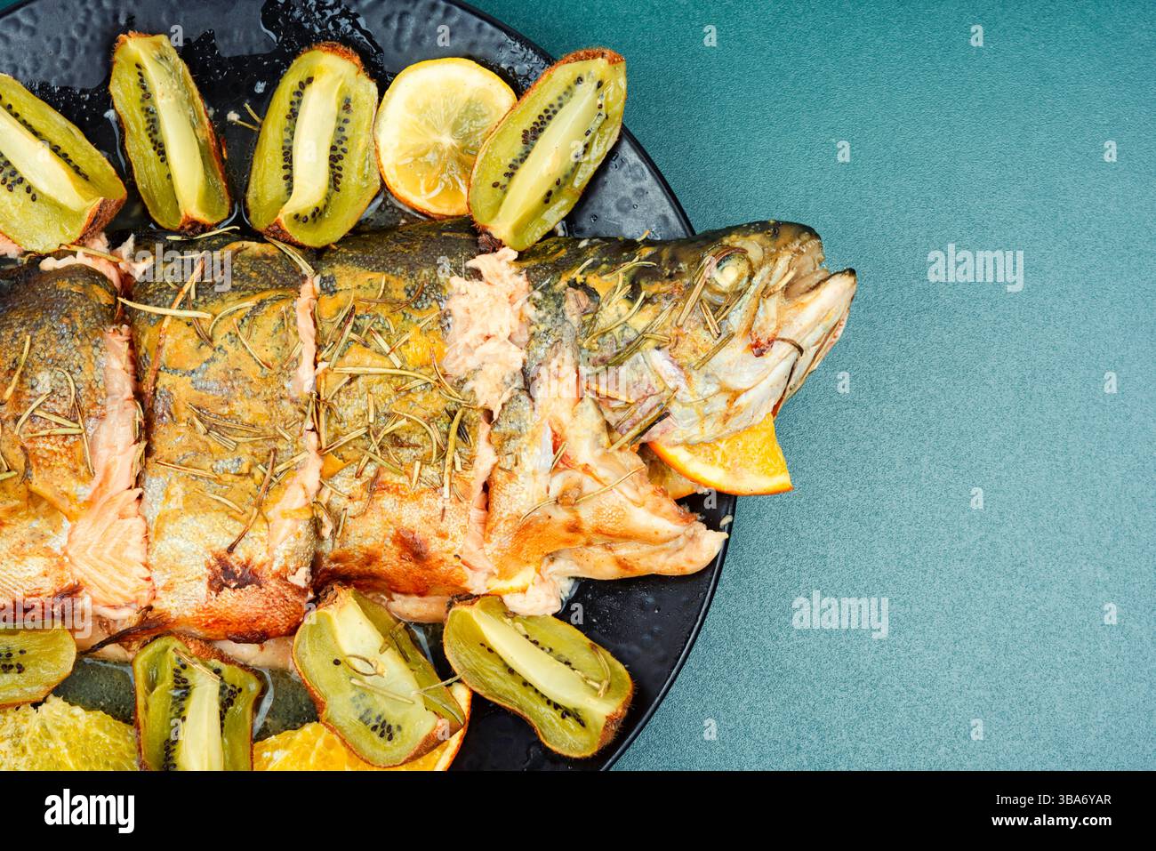 Trota tostata su un piatto, trota al forno con frutta. Foto Stock