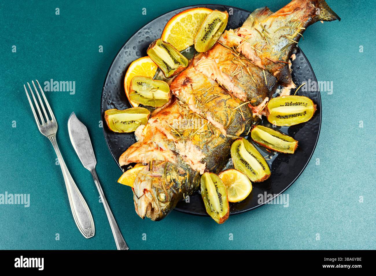 Delizioso pesce di trota al forno con kiwi e arancia. Foto Stock