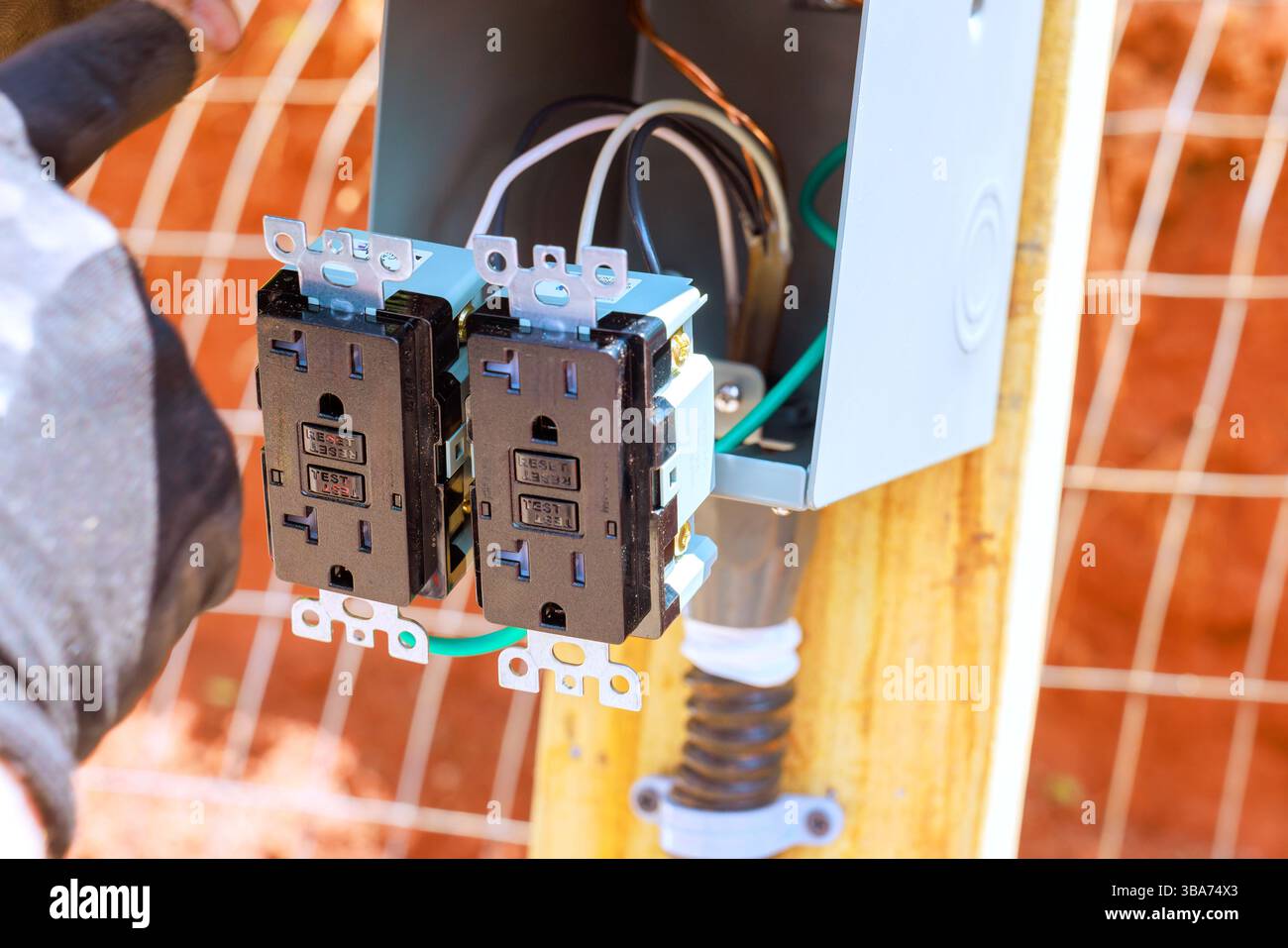 Il tecnico collega i cavi alle due prese esterne, garantendo una corretta installazione per la piena funzionalità. Foto Stock