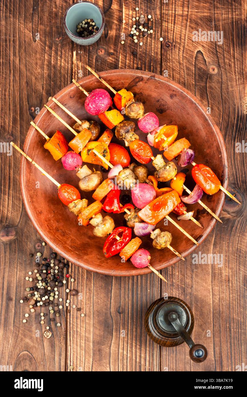 Verdure al barbecue. Spiedini di verdure barbecue su sfondo rustico in legno. Delizioso pasto al barbecue. Foto Stock