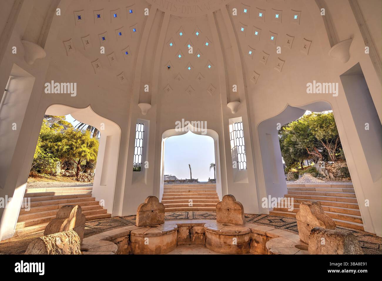 Un interno pieno di luce con pareti ornate, finestre e posti a sedere centrali in pietra che creano un ambiente armonioso, Kalithea, padiglione, Kallithea, bagno termale Foto Stock