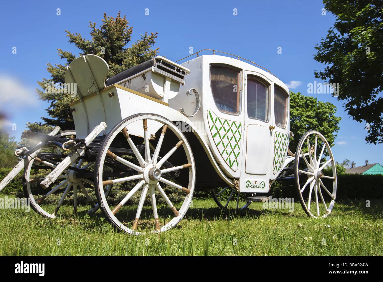 Un'antica carrozza bianca del XIX secolo su un prato verde. Il prototipo di un'auto moderna Foto Stock