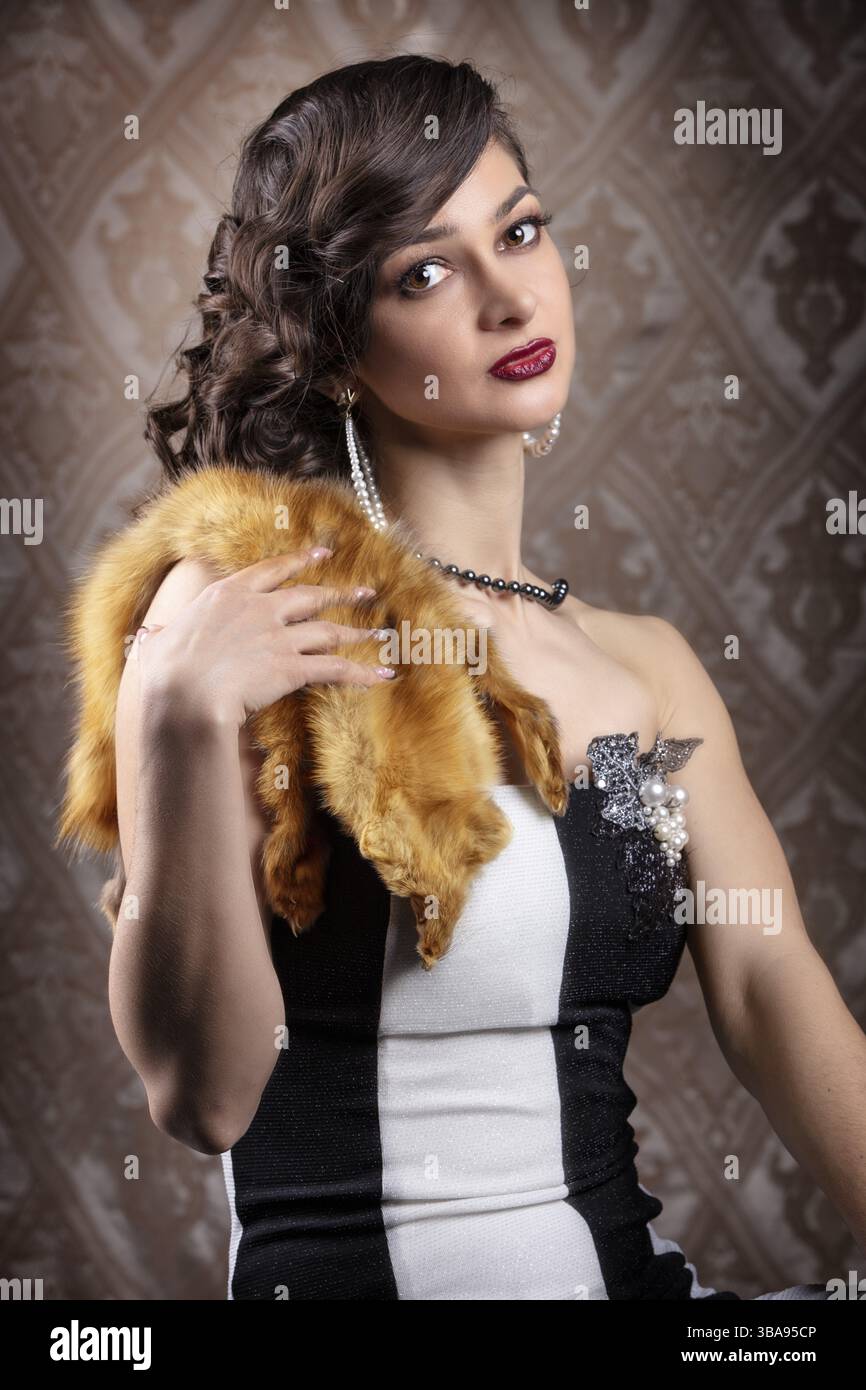 Ritratto retrò di una donna. Bella ragazza con pelliccia rossa nello stile degli anni '20 o '30 Trucco e acconciatura con le dita vecchio stile Foto Stock