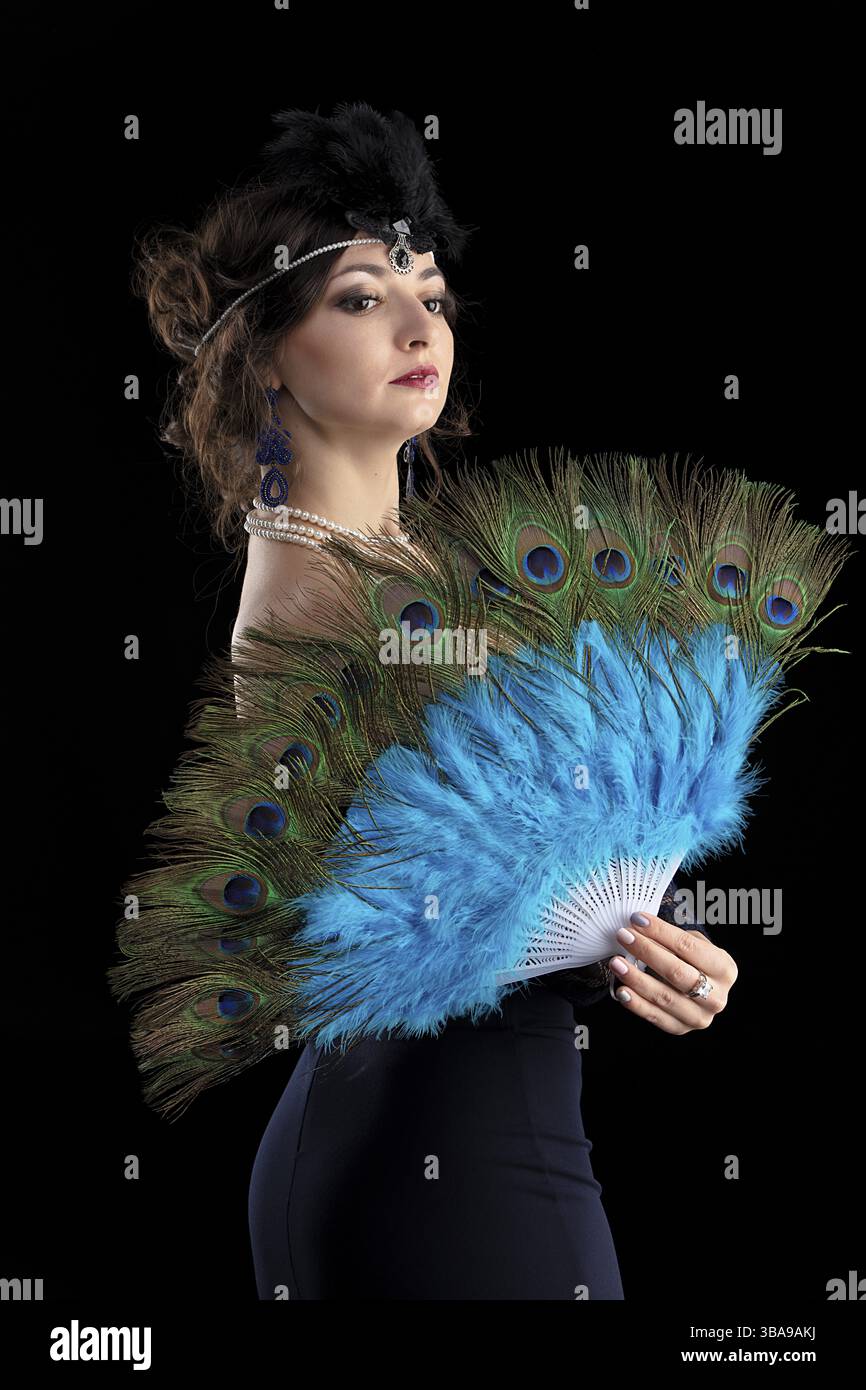 Ritratto retrò di una donna. Bella ragazza con un fan nello stile degli anni '20 o '30 Trucco e acconciatura con le dita vecchio stile Foto Stock