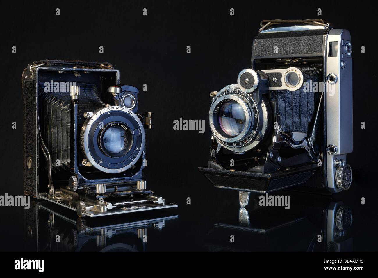 Due fotocamere vintage ripiegate rivelano dettagli e lavorazioni artigianali intricati, mettendo in risalto il fascino e la nostalgia delle prime tecnologie fotografiche. Foto Stock