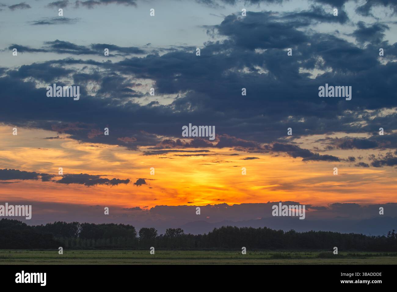 Tramonto vivido su un paesaggio verde lussureggiante con spettacolari campi nuvolosi Foto Stock