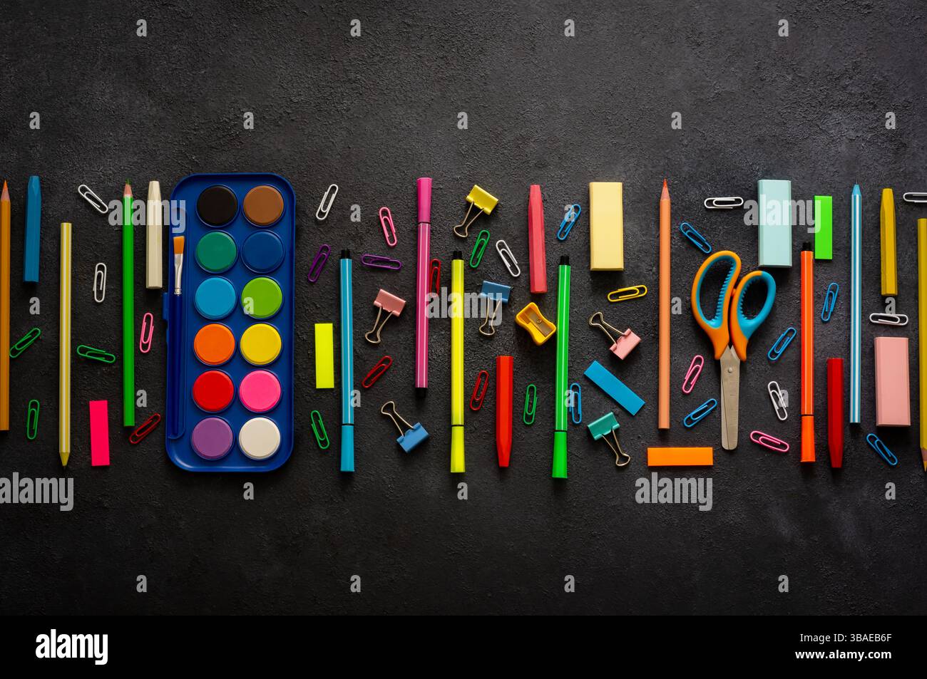 Concetto di ritorno a scuola, forniture scolastiche e accessori su sfondo nero, acquerello, matite, polvere, pastelli, spazio di copia con disposizione piatta Foto Stock