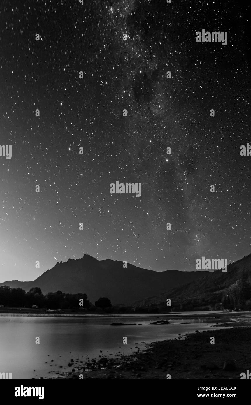 Bianco e nero lunga esposizione di cielo stellato sul lago Huechulaufquen e le sagome delle Ande al Parco Nazionale di Lanín, Patagonia, Argentina. Foto Stock