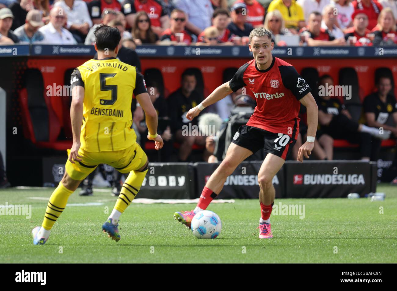 Leverkusen, Germania. 11 maggio 2025. Florian Wirtz (Bayer) AM Ball vor Ramy Bensebaini (BVB), Leverkusen, Deutschland, 11.05.2025, Fussball Bundesliga, 33. Spieltag, Bayer 04 Leverkusen - Borussia Dortmund I REGOLAMENTI del DFL VIETANO QUALSIASI USO DI FOTOGRAFIE COME SEQUENZE DI IMMAGINI E/O QUASI-VIDEO crediti: Juergen Schwarz/Alamy Live News Foto Stock