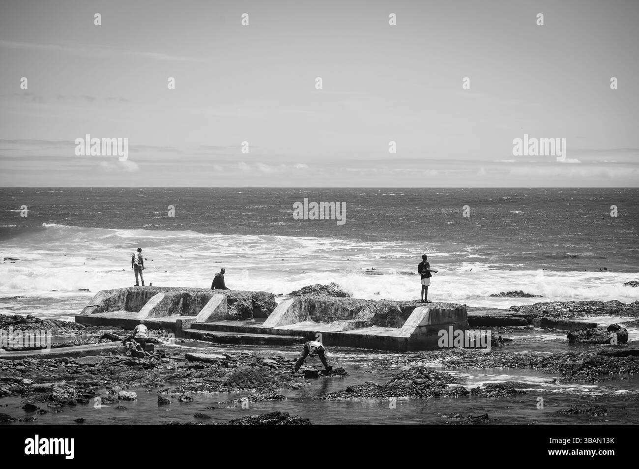 Pescatori e bagnanti sul mare lungo le pareti della spiaggia nel quartiere di Sea Point. Città del Capo, Sud Africa. Foto Stock