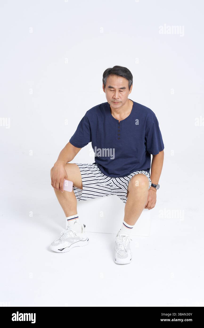 Un uomo anziano stanco seduto e riposato Foto Stock