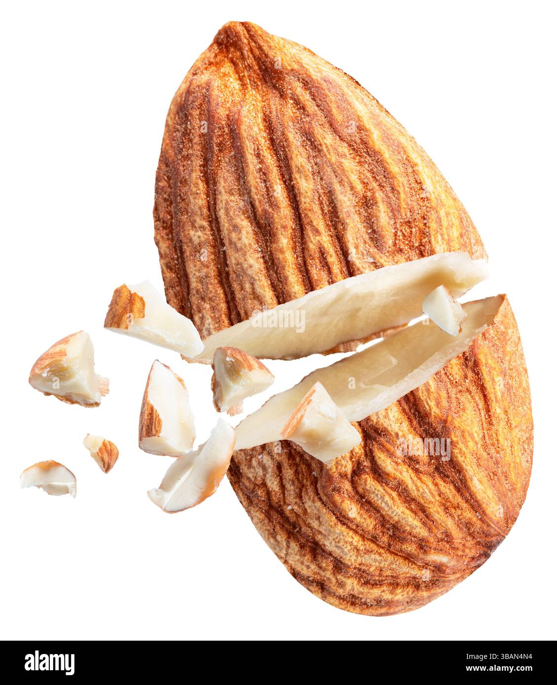 Il dado di mandorla si è incrinato a metà e i pezzi di mandorla volano lontano da esso, isolati su sfondo bianco. Il file contiene il percorso di ritaglio. Foto Stock