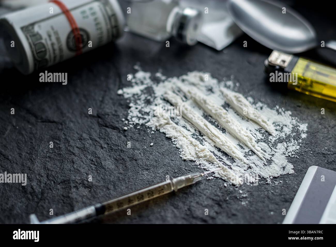 concetto di problema di tossicodipendenza. primo piano di polvere di cocaina o eroina, siringa, cucchiaio, accendino per paraphernalia e banconota del dollaro dello spacciatore Foto Stock