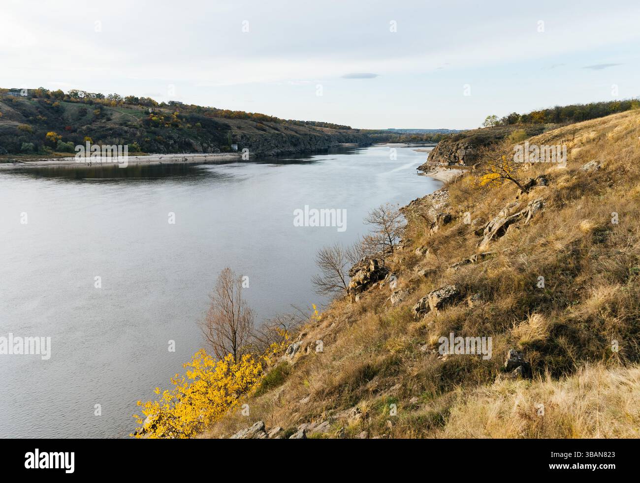 Vista da un'alta sponda del fiume sull'ampio letto e sulla spiaggia sulla riva opposta in autunno. Foto Stock Vista da un'alta sponda del fiume sull'ampio letto e sulla spiaggia sulla riva opposta in autunno. Foto Stock