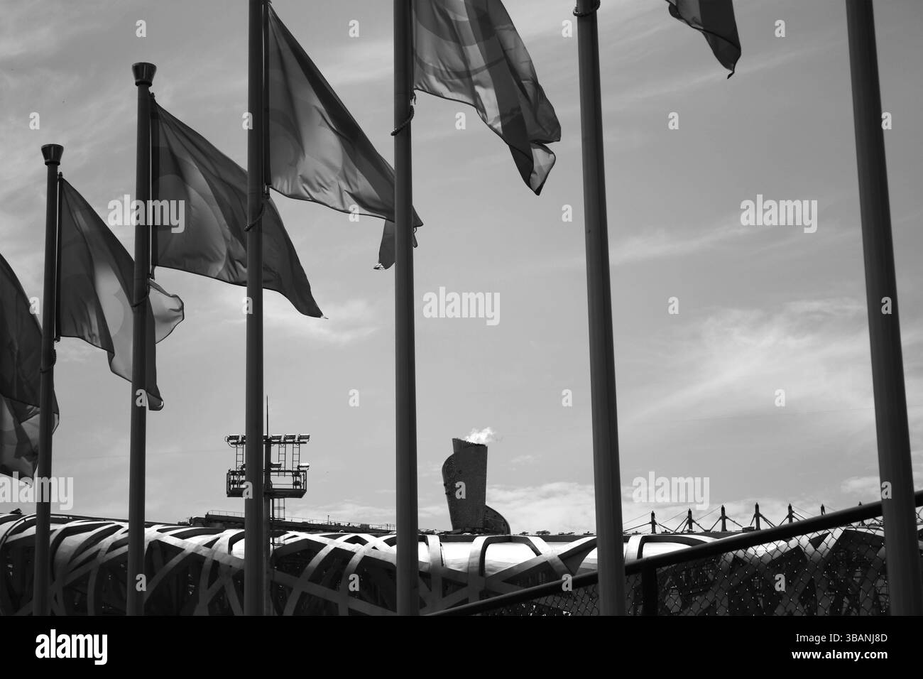 Foto in bianco e nero delle bandiere olimpiche e della struttura dello Stadio Nazionale di Pechino durante i Giochi estivi del 2008 Foto Stock