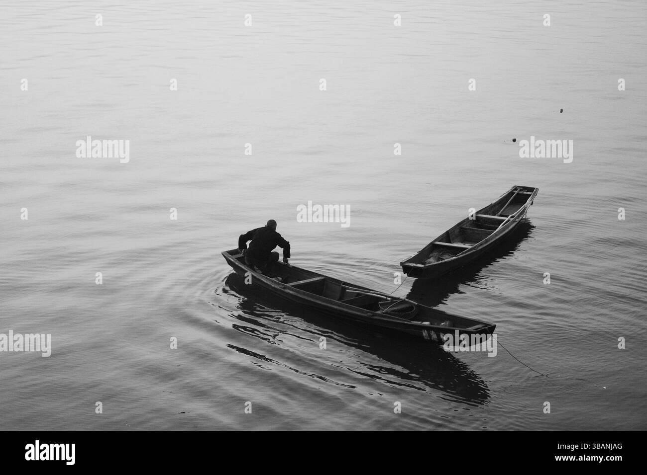 Barcaiolo tradizionale sul fiume Qiantang, Hangzhou, Cina - composizione minimalista monocromatica che cattura la vita sul fiume nel 2012, Hangzhou, Zhejiang, Cina Foto Stock